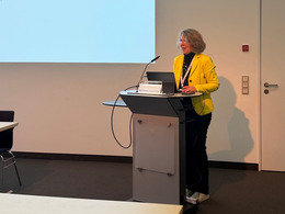 A woman is standing at a lectern.