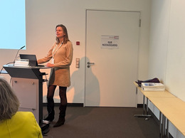 A woman is standing at a lectern.